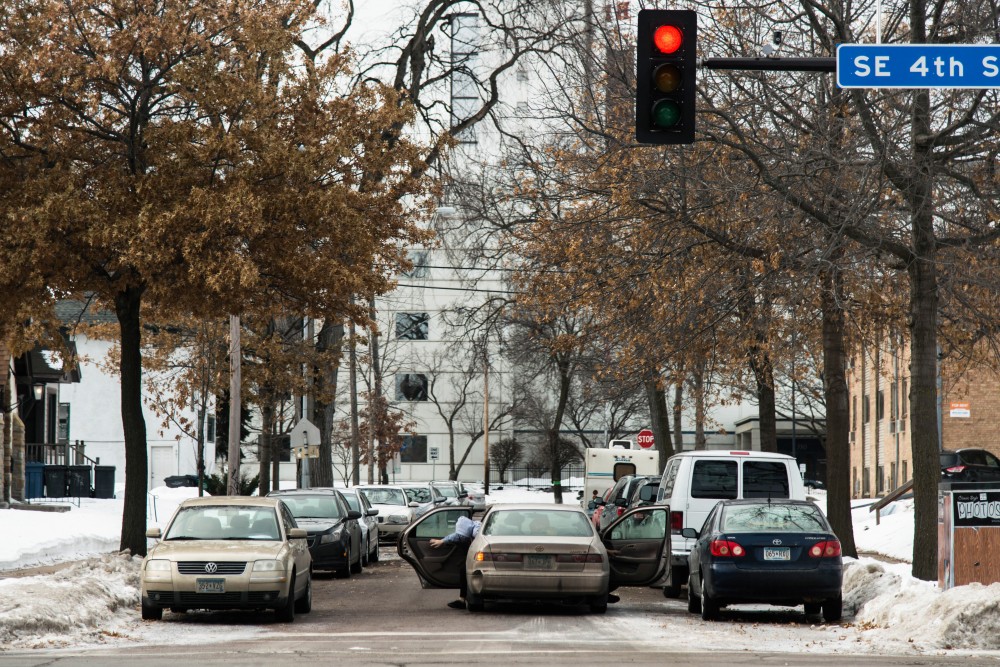 Sunday morning church goers exit their vehicle  on a nearly-full section of 4th Ave SE in Marcy-Holmes, Sunday, Jan. 28. The Church of Minneapolis, along 4th Street SE has had issues with members finding parking in the neighborhood.