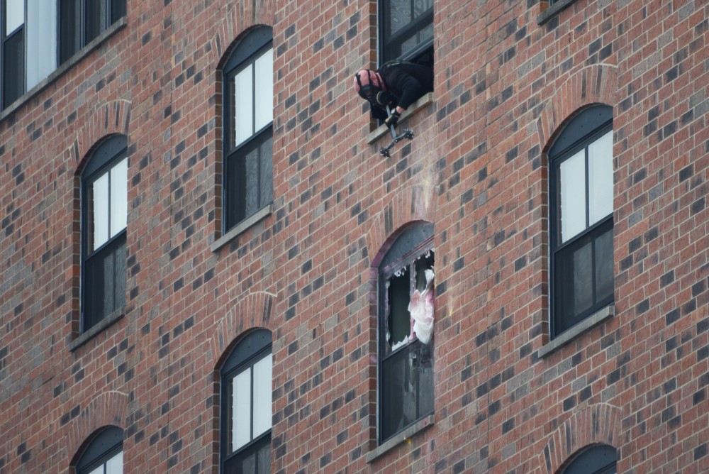 An officer looks down at the sixth floor window of the room at the Graduate Hotel where Bowman was located Tuesday.
