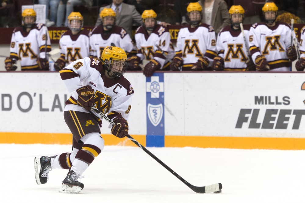 The Gopher womens hockey team watches on as senior defenseman Sydney Baldwin brings the puck down the ice on Dec. 1, 2017 at Ridder Arena. 