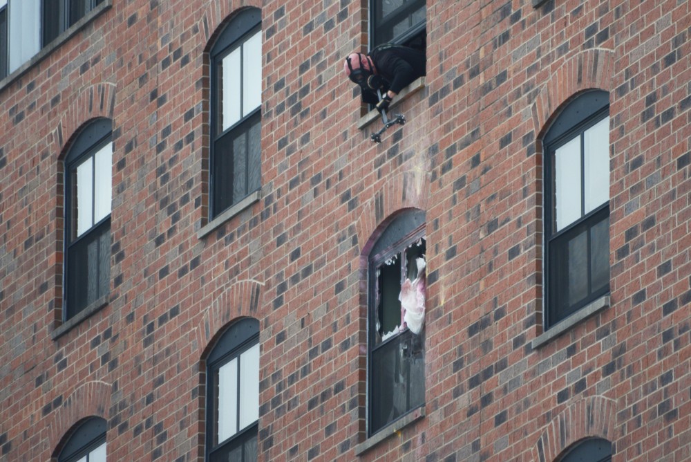 An officer looks down at the sixth floor window of the room at the Graduate Hotel that the suspect was in. 
