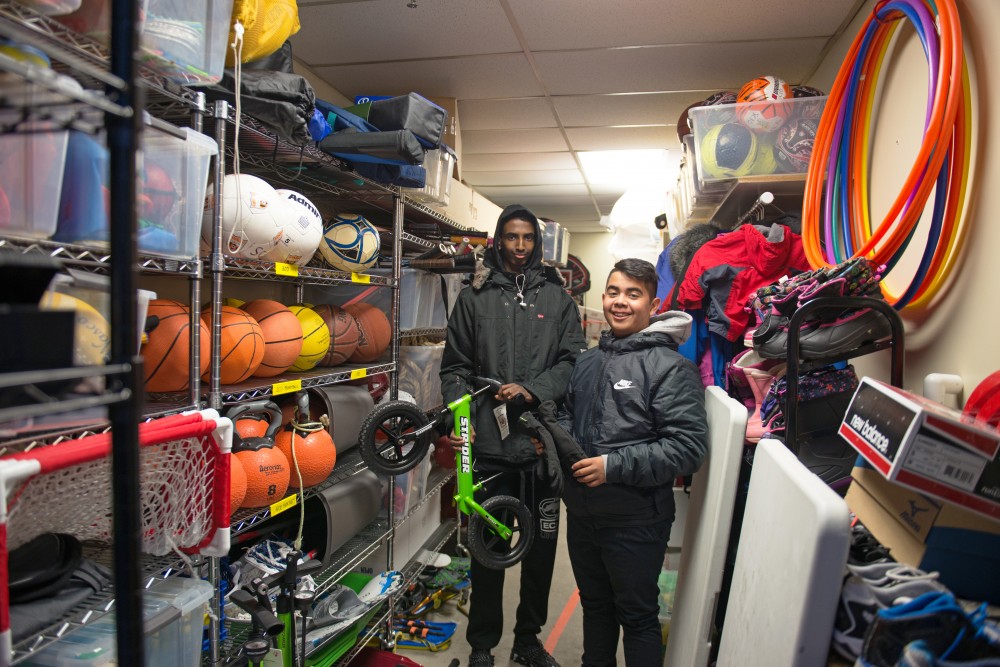 Hamsa Osman, left and Charly Tiempos founders of Sports Check it Out, a sports equipment checkout program in Cedar Riverside stand in the check out room where they rent out a variety of equipment to neighborhood kids.