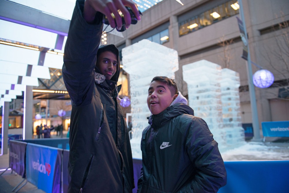Hamsa Osman, left, and Charly Tiempos video blog the downtown festivities for the Super Bowl. The founders both have a following on social media where they currently share their Super Bowl experience. 
