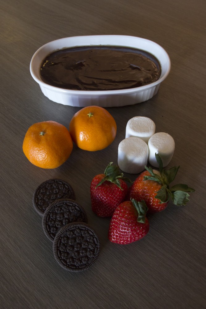 Chocolate fondue with fruits and sweets to dip.