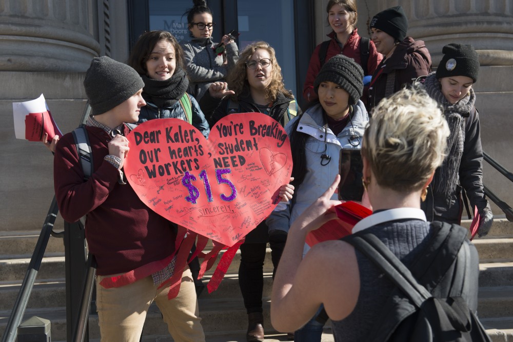 Members of the 15 for Student Workers group sing outside of Morril Hall on Wednesday, Feb. 14. Two students were eventually let in to deliver the large valentine card the group the created to University President Eric Kaler.