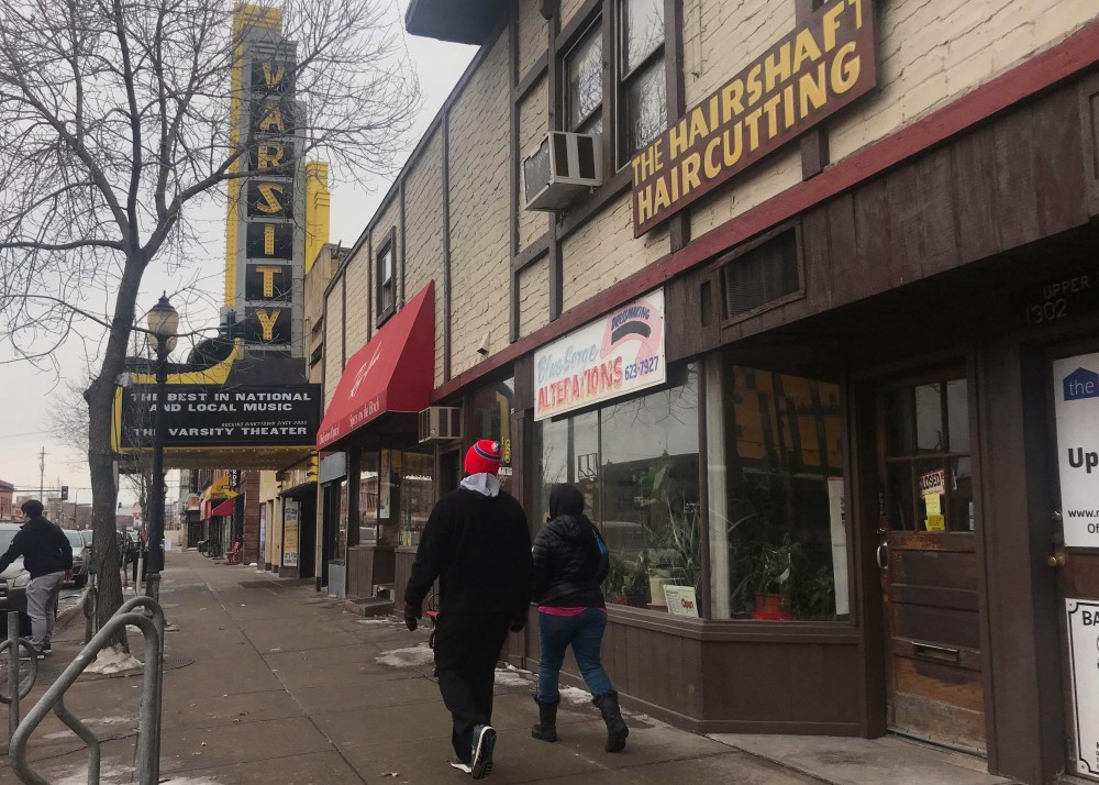 People walk past businesses on 4th Street Southeast in Dinkytown on Sunday, Feb. 18. A group of businesses are being forced to close after the buildings owner decided to sell the property.
