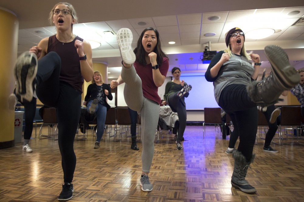 From left, Rebecca Sedivy, Megan Doi and Megan LaBat practice kicking attacks during the self defense workshop in Coffman Union on Saturday, Feb. 24.