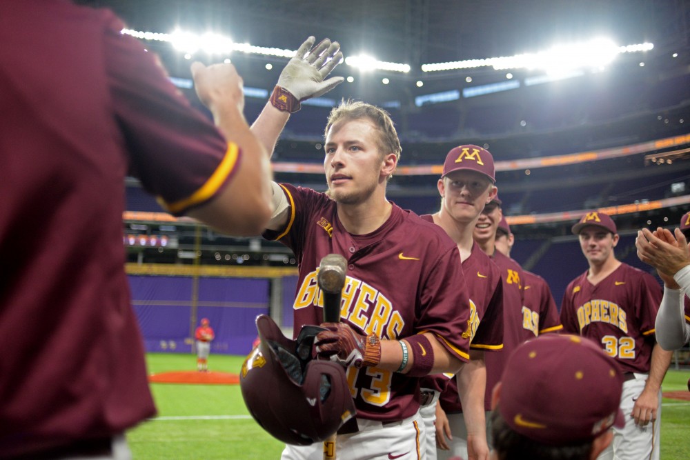 Infielder Luke Pettersen high-fives a teammate after scoring his first collegiate home run during a game against St. Johns University at US Bank Stadium on March 30. 