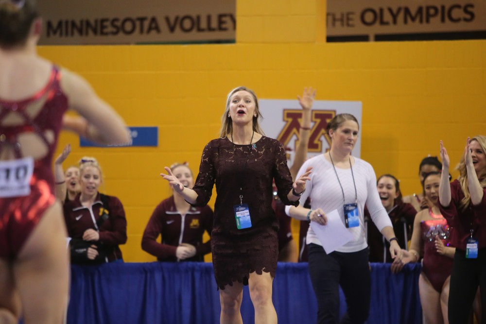 Assistant Coach Geralen Stack-Eaton runs to congratulate Freshman Lexy Ramler on her balance beam routine at the Regional NCAA Gymnastics Championship on Saturday, April 7 in Minneapolis.