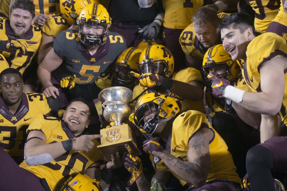 The Gold team celebrates a win of the first Goldys Cup during the Gophers football spring game at TCF Bank Stadium on Thursday, April 12.