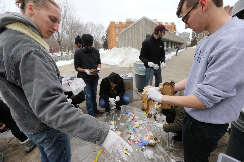 Environmental science policy management senior Eli Miller and strategic communications sophomore Jacob Van Blarcom sift trash from the Coffman Marketplace food court that wasnt already tossed into the correct recycling, compost or waste bin on Wednesday, April 18 outside Williamson Hall. 
