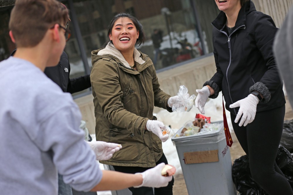 Strategic communications sophomore Schuyler McKinley sifts through trash from Coffman Marketplace food court that wasnt already tossed into the correct recycling, compost or waste bin on Wednesday, April 18 in outside Williamson Hall.
