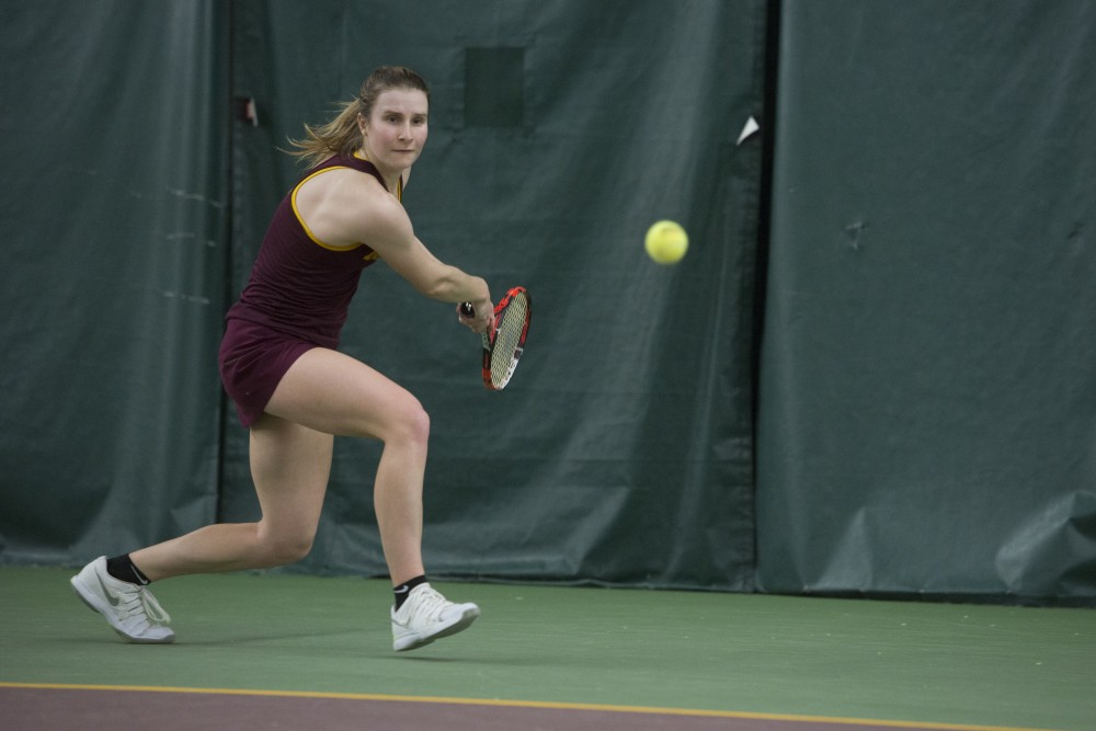 Senior Caroline Ryba competes in her singles match against the University of Michigan at Baseline Tennis Center on Friday, March 23.