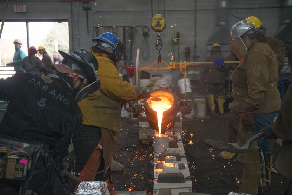 Iron pours from a crucible during the 49th Annual Iron Pour: Star Pours in the Foundry and Sculpture Courtyard. 