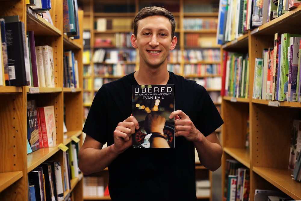 Evan Kail, author of Ubered poses with a copy of his book at Magers & Quinn bookstore on Tuesday, May 29, 2018 in Minneapolis. Kail no longer drives Uber.