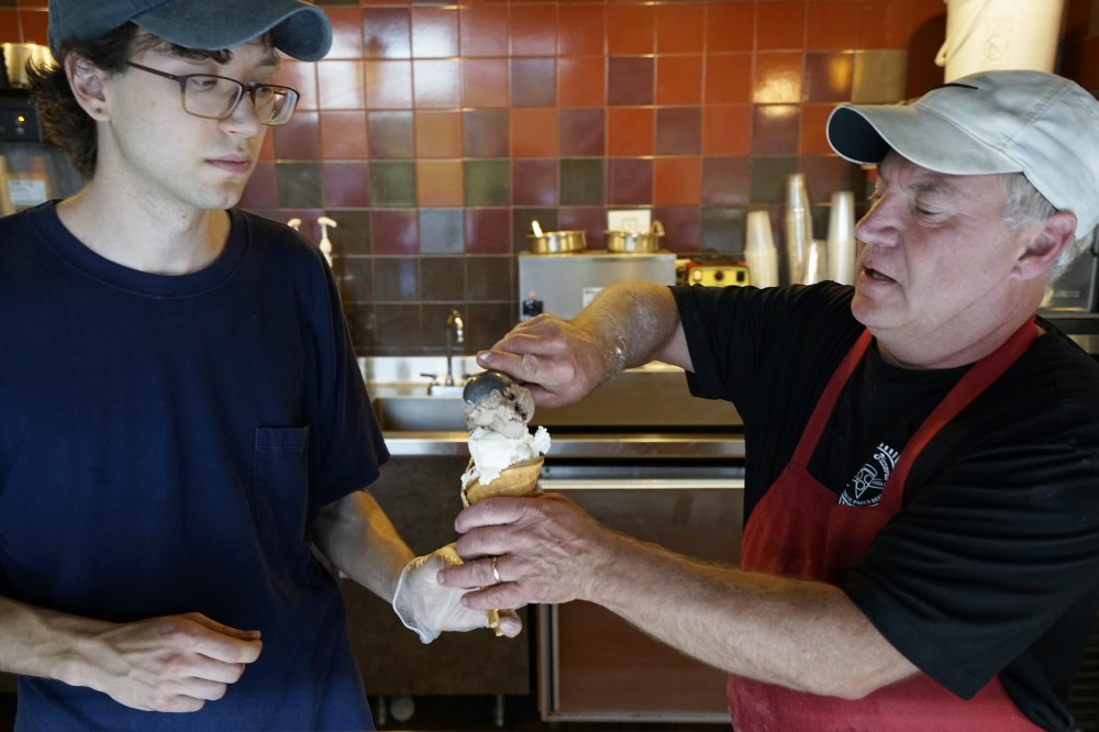 Greg Galles scoops ice cream into a homemade waffle cone at the Purple Onion Cafe on Saturday, May 26. The Purple Onion now features St. Pauls Grand Ole Creamery ice cream.