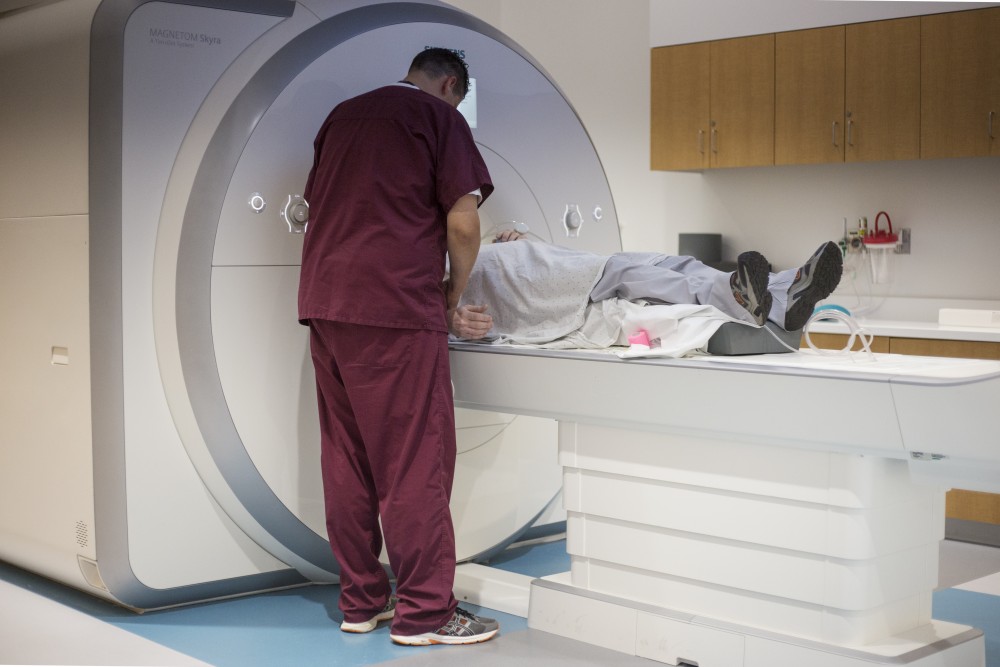 A MRI technician injects contrast dye into a patients IV during an MRI of their brain at the University of Minnesota Health Clinics and Surgery Center on Monday, June 25 in Minneapolis. 