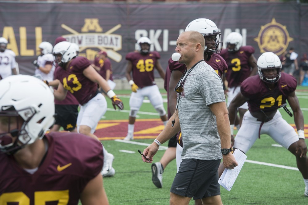 Head Football Coach P.J. Fleck blows a bubble at the Athletes Village practice field on Monday, Aug. 20. 