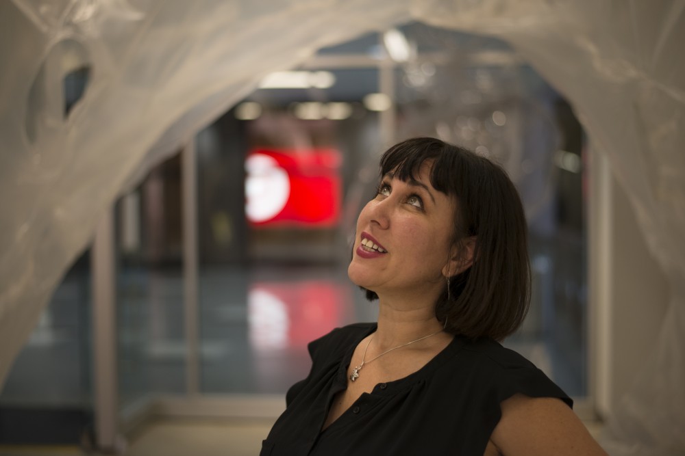 Paige Dansinger, the founding director of Better World Museum in Minneapolis, poses for a portrait inside of Asia Wards piece, Cocoon, on Tuesday, Sept. 11.  The work is made entirely out of plastic used to cover boats. 