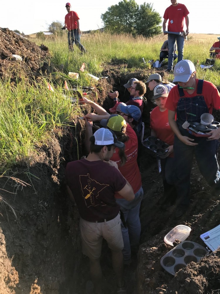 Matt Bluhm and the University of Minnesota soil judging team are seen in the fray of an individual pit.
