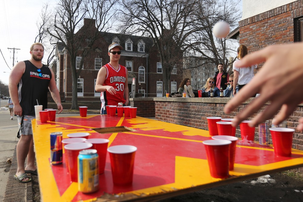 Zach Kosel and Dan Davidson watch to see if they make the cup during a beer pong game outside their fraternity on Friday, April 20 in Minneapolis. 