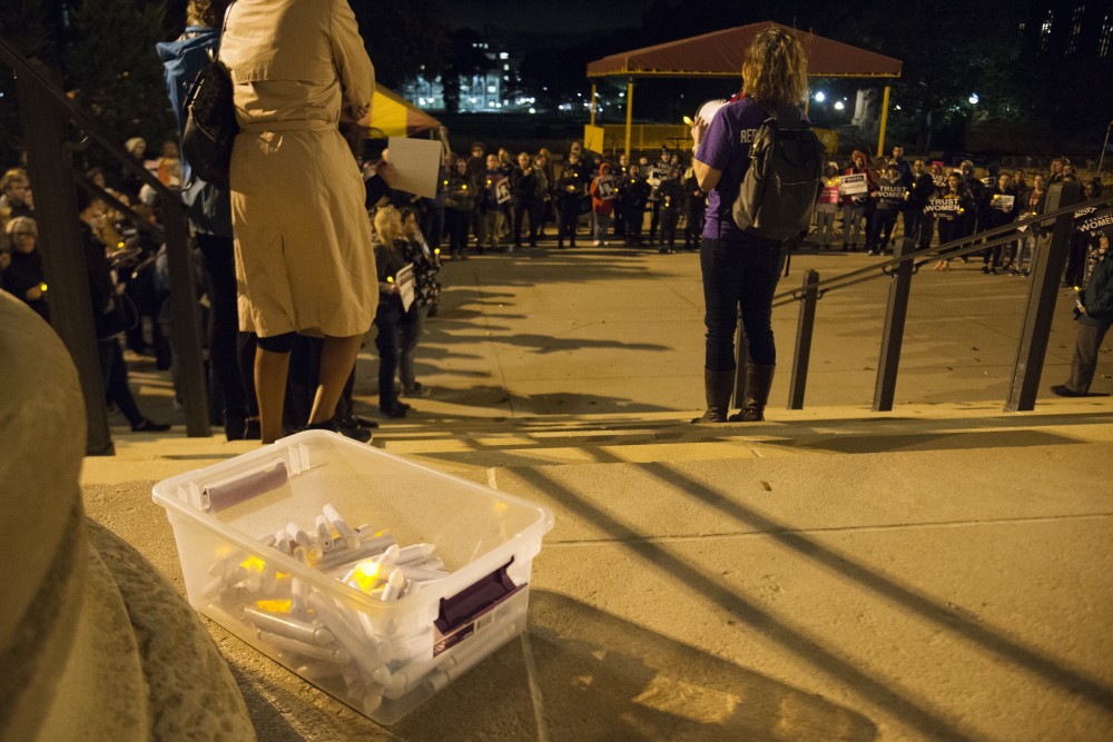 Supporters of Dr. Christine Blasey Ford gathered at Northrop Plaza for a vigil on Wednesday, Oct. 3. Event organizers handed out electric candles to supporters to hold during a moment of silence for survivors of sexual assault.