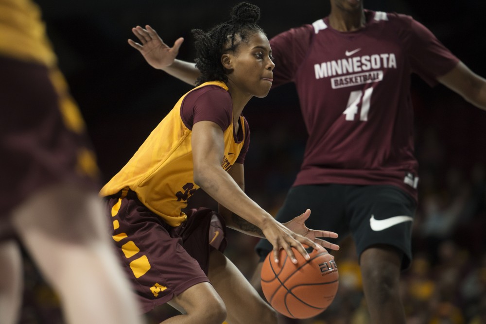Guard Kenisha Bell dribbles through the defenders during Gopher womens basketballs annual exhibition versus the mens scout team on Saturday, Oct. 20 at Williams Arena.