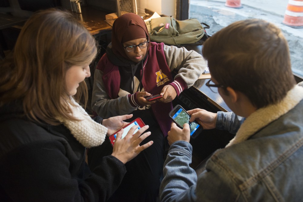 DFL Youth Coordinators Michaela Muza, left, Faisa Ahmed and Riley Fletcher operate the app, MiniVAN, at Black Coffee and Waffle Bar in Como on Tuesday, Oct. 23. MiniVAN tells them where registered voters live so they can be more effective in getting the word out about voting by door knocking.