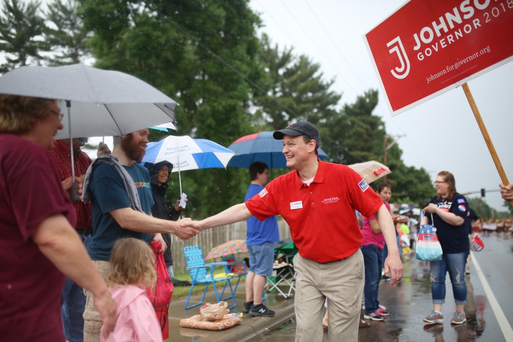 GOP-endorsed candidate for Minnesota Governor Jeff Johnson shakes hands with parade spectators at the Father Hennepin Parade in Champlin, Minnesota on Saturday, June 9.