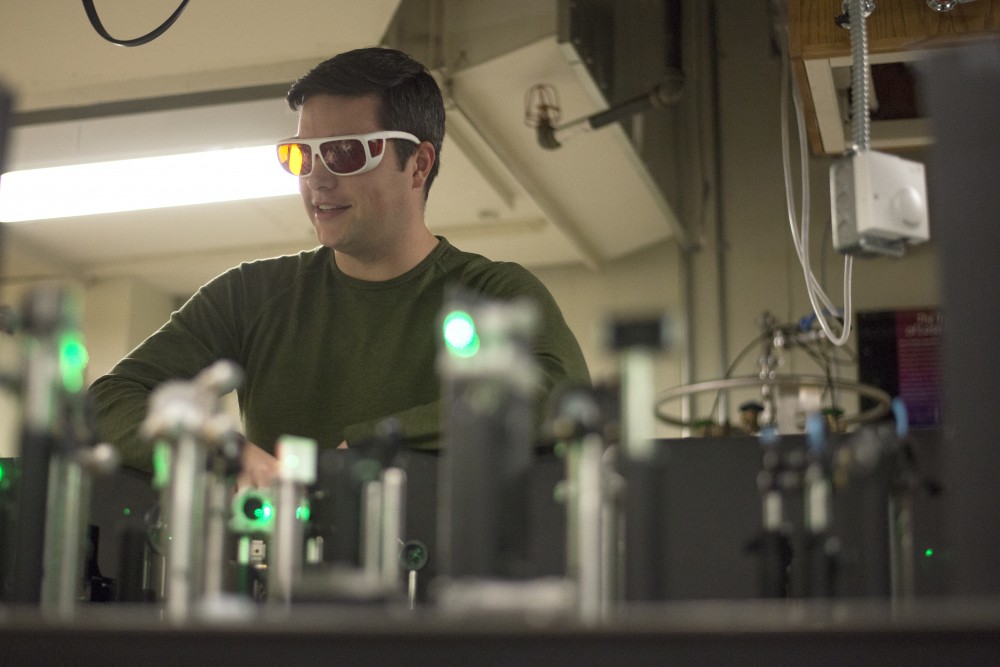 Chemistry graduate student Harrison Frisk demonstrates how his ultrafast laser spectroscopy setup works in his lab at Kolthoff Hall on Thursday, Oct. 11. 