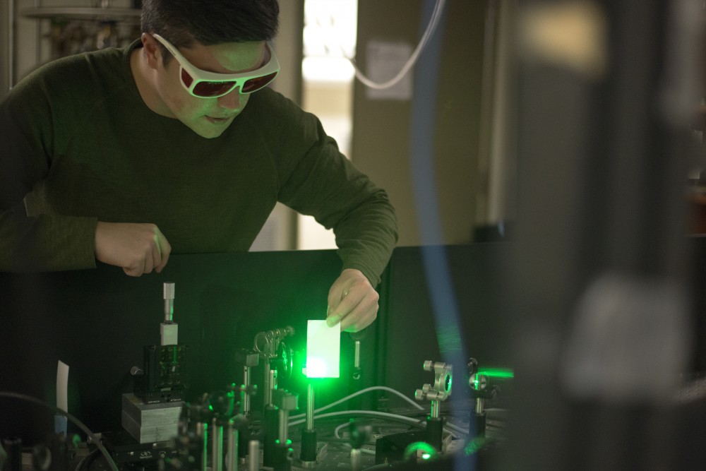 Harrison Frisk, a fifth-year graduate student in the Department of Chemistry, shows the power of the lasers in his ultrafast laser spectroscopy table. The lasers come from a single unit and are bounced off crystals, some of which are grown in the lab, before they reach a special chamber that holds a two-dimensional crystal which allows Frisk to study the physics of the electrons in the light. 