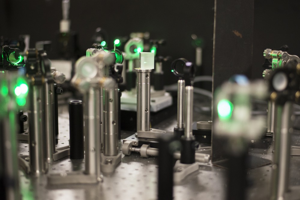 Lasers bounce off of a crystal prism and then a series of meticulously placed, lab-grown crystals on an ultrafast laser spectroscopy table in University graduate student Harrison Frisks lab in Kolthoff Hall on Thursday, Oct. 11. 