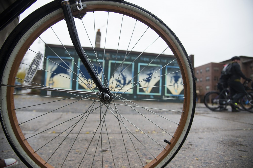 An alley mural is seen through a bikers wheel on Sunday, Nov. 4. The ride, hosted by the Minneapolis Alley Initiative for Neighborhood Stimulation, features public art in the Longfellow and Powderhorn neighborhoods. The organization keeps a map online for others for follow on their own time. 