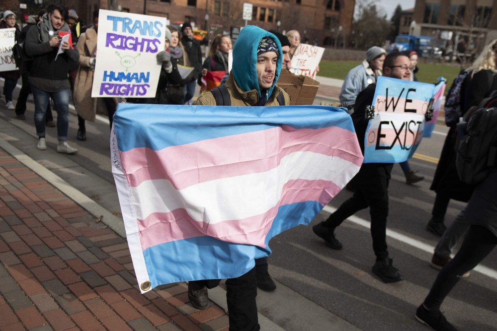 Daniel Palmer marches across the University of Minnesota campus with a transgender flag on Thursday, Nov. 8. Members and allies of the transgender community marched across campus in support of transgender rights. 