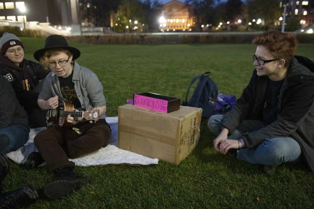 Jimmy Cooper, center, plays the ukulele during a trans rights protest show on Tuesday, Oct. 30 in the lawn in front of Coffman Union. Cooper put together the show and took donations for the Trans Justice Funding Project. 