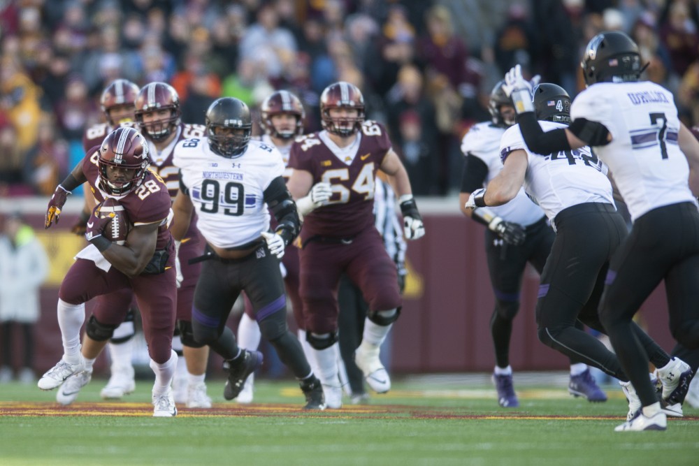 Runningback Jonathan Femi-Cole takes off with the ball during the game against Northwestern on Saturday, Nov. 17 at TCF Bank Stadium.