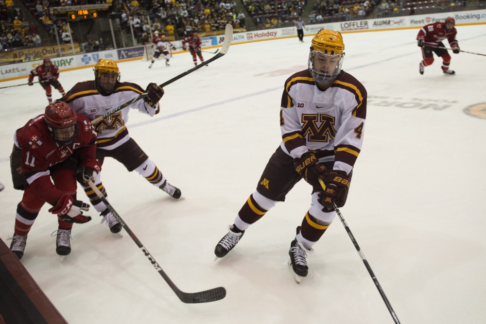 Freshman Ben Brinkman keeps the puck away from St. Lawrence on Saturday, Nov. 17 at Mariucci Arena. 