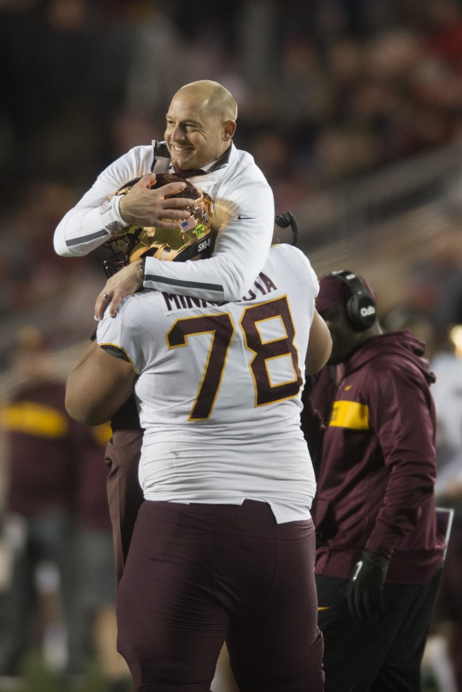 Coach P.J. Fleck embraces offensive lineman Daniel Faalele at Camp Randall Stadium in Madison on Saturday, Nov. 24, 2018. The Gophers beat the Badgers 37-15 for the first time since 2003.