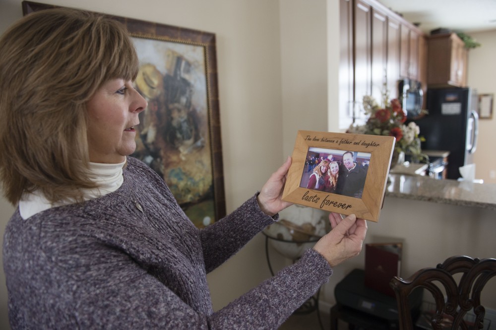 Diane Houle holds a picture of her husband and daughter, Jennifer Houle, at her home in Woodbury on Tuesday, Dec. 11. Houles daughter Jennifer was a student at the University and died of suicide in 2015. 