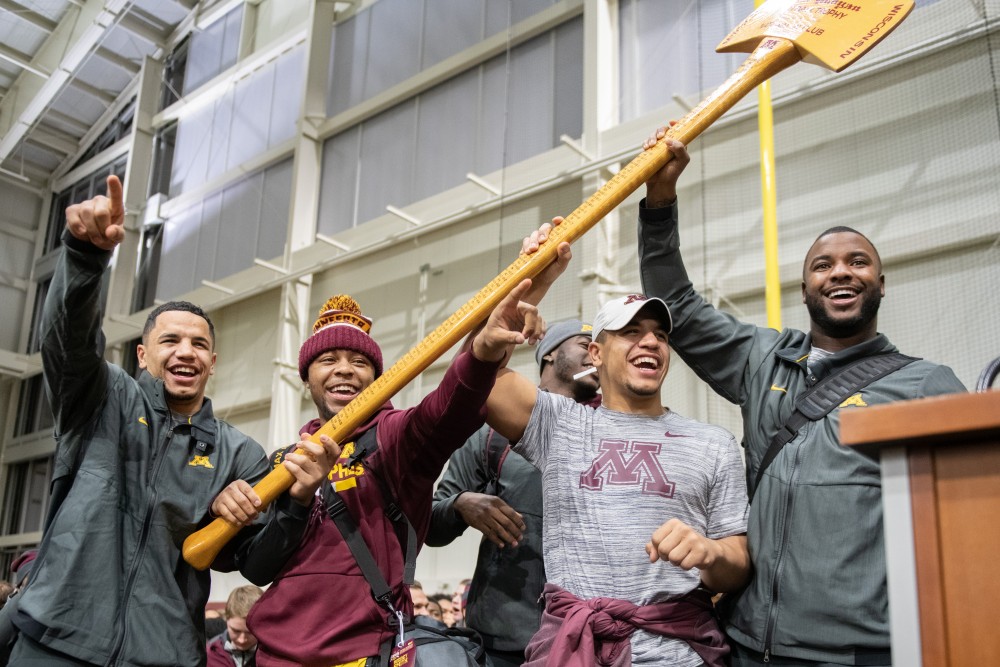 Members of the Gopher football team hold up the axe on Saturday, Nov. 3, 2019, at the football teams indoor practice when the team returned from their win in Madison, Wisconsin. 