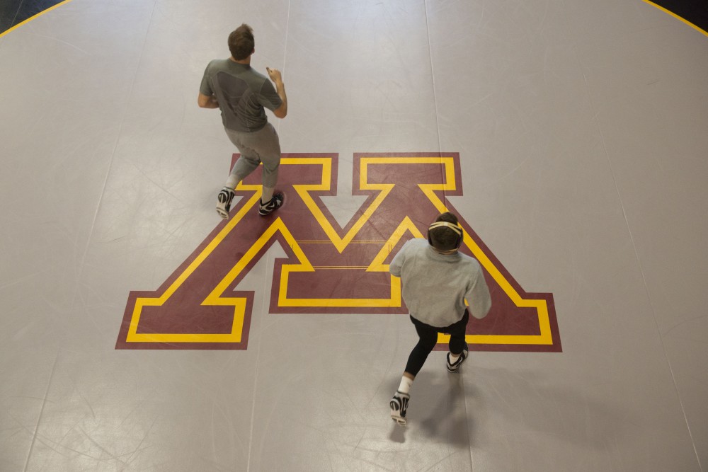 Members of the wrestling team jog during practice at the new Gopher Wrestling Training Facility on Wednesday, Jan. 23. 