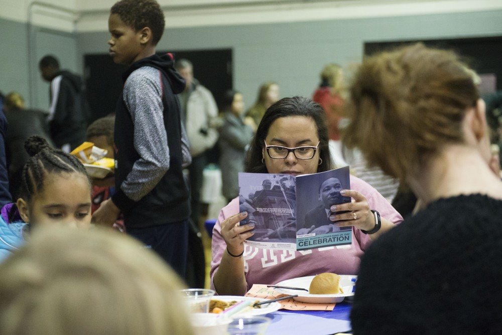 Dennisha Ford reads a program for the event held on Monday, Jan. 21 at the Powderhorn Recreation Center in Minneapolis. The 21st annual celebration of the Rev. Dr. Martin Luther King Jr., held by the Seward Co-op, drew around 250 people. 