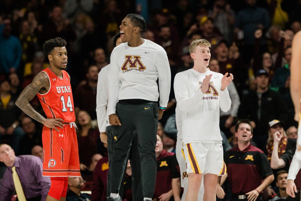 Marcus Carr celebrates on the bench with his Gophers teammates in a game against Utah.