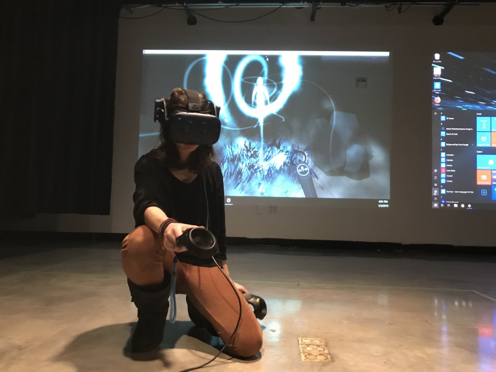 Melinda Hiller works in VR to create the drawings that are projected behind her. 