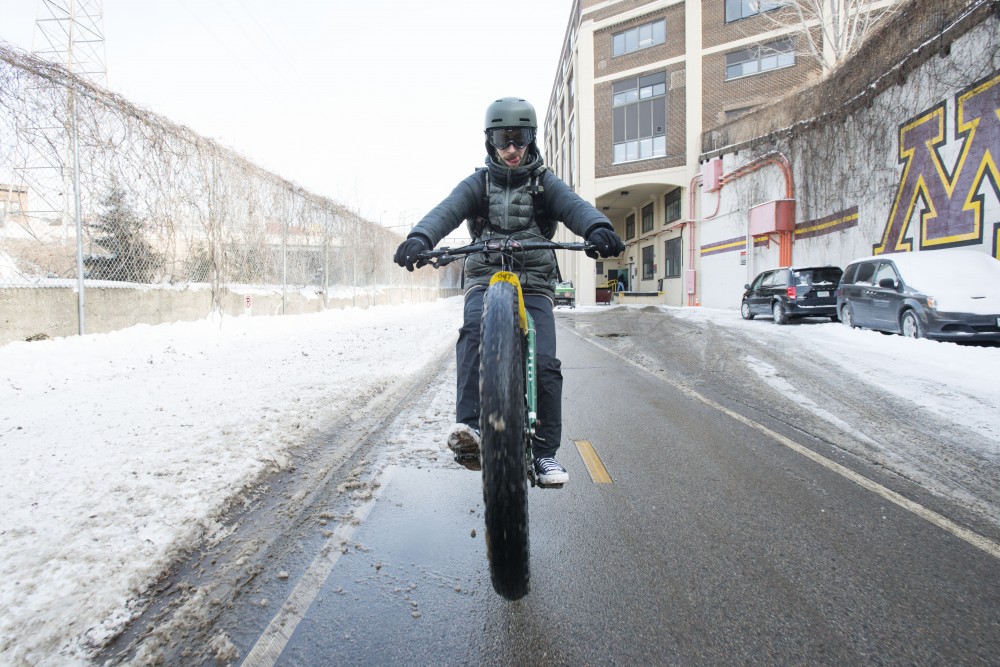 Bennett Figueroa pops a wheelie on his bike as he rides down the Dinkytown Greenway on Friday, Feb.1