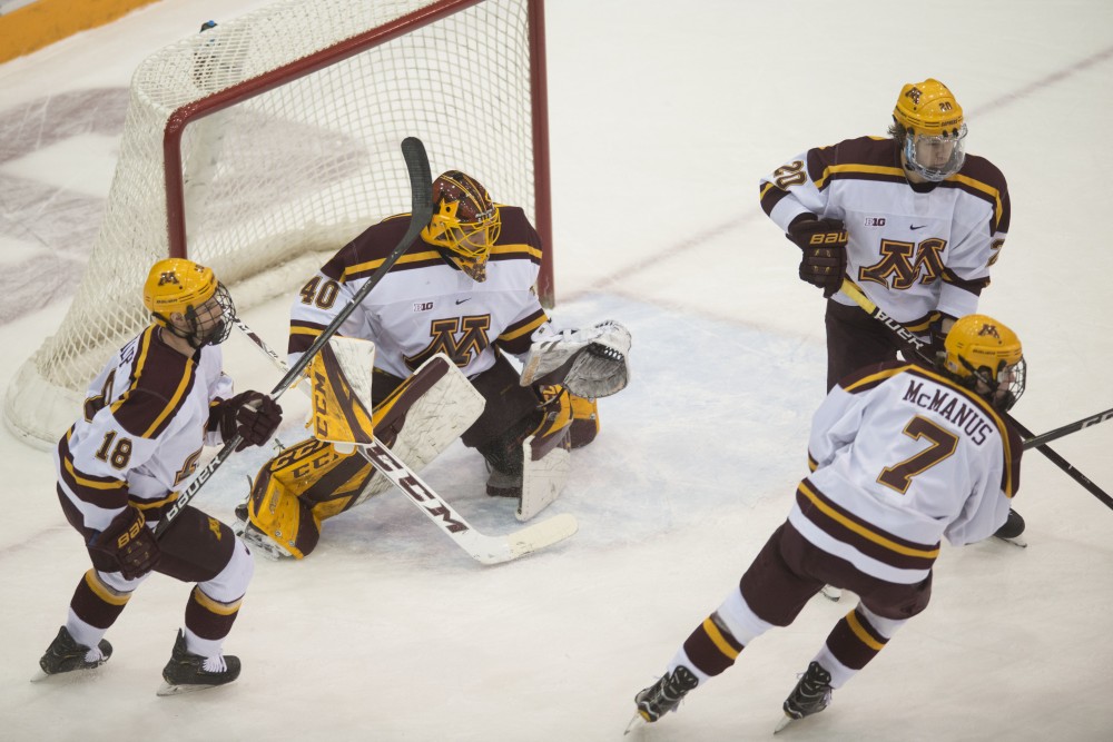 Members of the gopher mens hockey team help goalie Mat Robson keep the puck out of the net on Saturday, Jan. 26 2019 at 3M Arena at Mariucci.