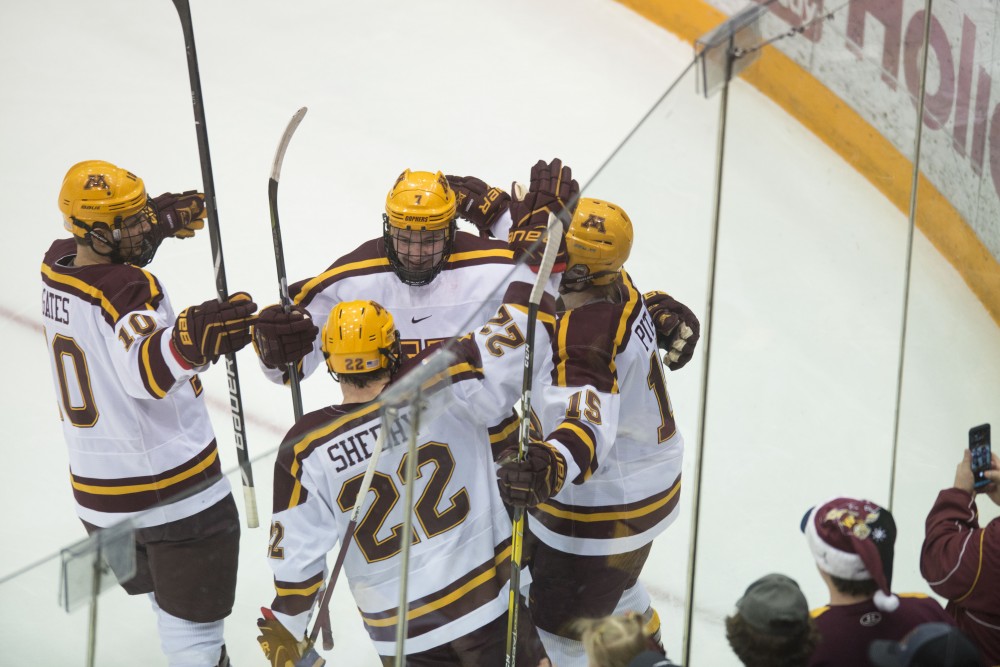 Top line members Brent Gates Jr., Tyler Sheehy and Rem Pitlick congratulate teammate Brannon McManus after he scored a goal on Saturday, Jan. 26 at 3M Arena at Mariucci.