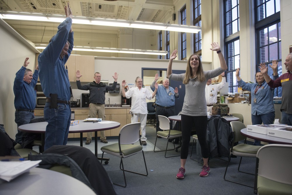Andrea Santi leads University Facilities Management employees in pre-shift stretch on Friday, Feb. 15. The program was started by Santi and fellow graduate student Nael Banat as part of their Kinesiology studies. 
