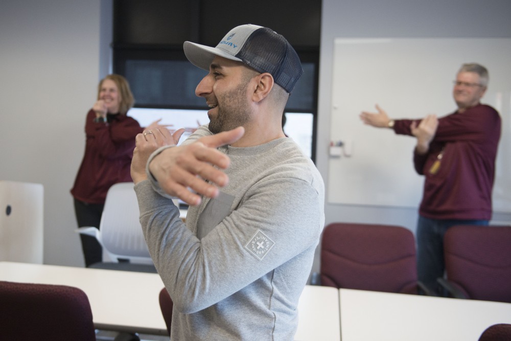 Nael Banat leads University Human Resources employees in a pre-shift stretch on Friday, Feb. 15. The program was started by Banat and fellow graduate student Andrea Santi as part of their Kinesiology studies. 