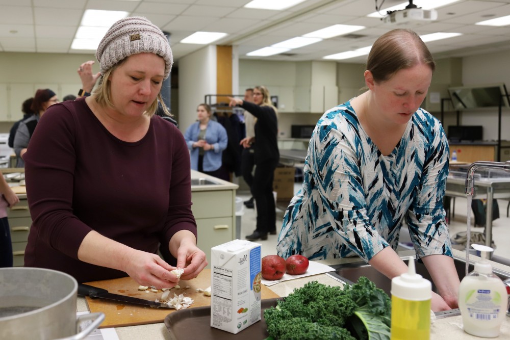 Lisa Spofford and Amy Boll-Wilson chop garlic at an employee wellness program on Monday, Feb. 25 at McNeal Hall in St. Paul. 