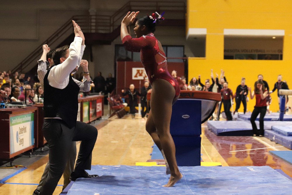 Paige Williams is congratulated by her coach after vaulting on Saturday, March 2 at Maturi Pavilion.